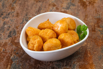 Sweet tasty profiteroles heap in the bowl