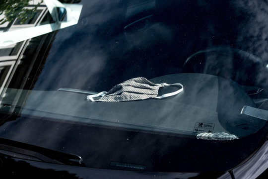 Eine selbst genähte Atemschutz Maske liegt auf dem Armaturenbrett eines Autos