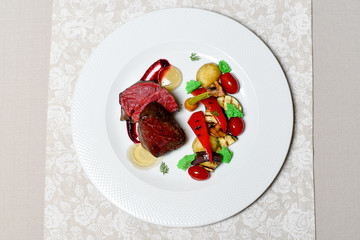 Meat steak with vegetables on a white plate