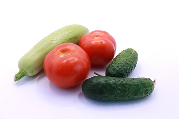Photo of tomatoes, cucumbers and zucchini on a white background, close-up
