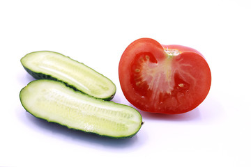 Photo of young cucumbers and tomato on a white background, close-up