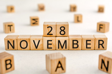 November 28 - from wooden blocks with letters, important date concept, white background random letters around