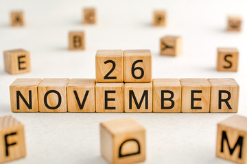 November 26 - from wooden blocks with letters, important date concept, white background random letters around