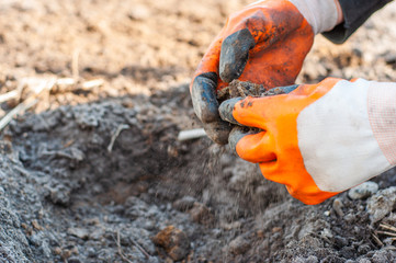 Grinding hard rock with rubber gloves.