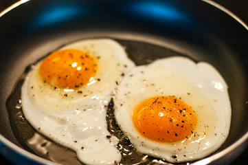 Making the perfect breakfast of two fried egg seasoning.
