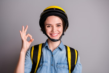Portrait of positive cheerful girl courier approve covid-29 quarantine delivery food service show okay sign carry yellow thermo bag wear denim jeans shirt isolated silver color background