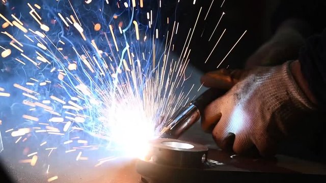 Welder worker at industrial arc welding work