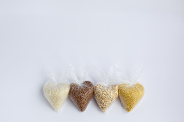 various groats in plastic bags on a white background