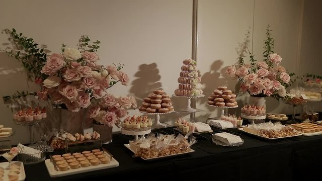 A beautiful candy buffet table at a wedding with delicate pastel colors
