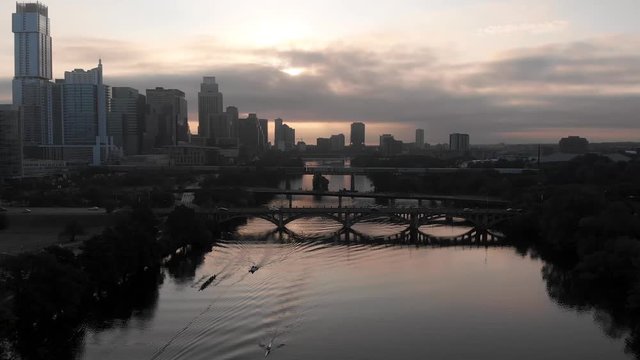 As the sunrises over the Austin, Texas skyline, a rowing crew cut through the waters of the Colorado River on a morning workout.