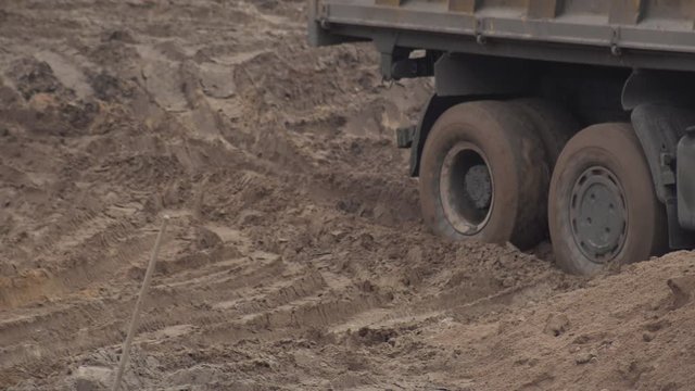 A construction truck stalled in the sand. Center differential lock, background, industry. Wheel grip