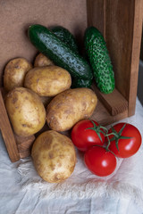 Potatoes, cucumbers and tomatoes in a box