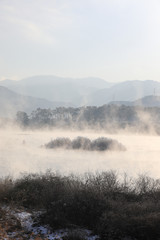 Naklejka na ściany i meble Winter morning landscape of water misty river. Soyang River, Chuncheon City, Korea