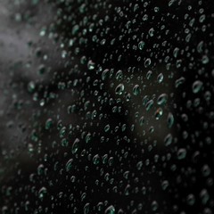 Background of raindrops on car glass at dusk