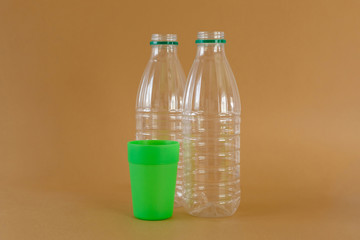 Plastic bottles and glass on a brown background