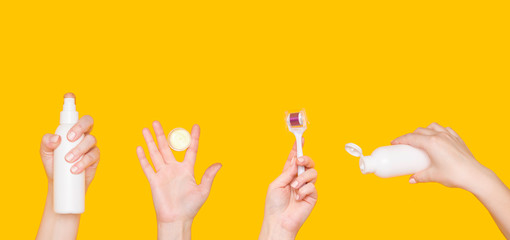 Body care products in women's hands separately at the bottom of the photo. Yellow background. Women's health, beauty cosmetics and dermaroller.