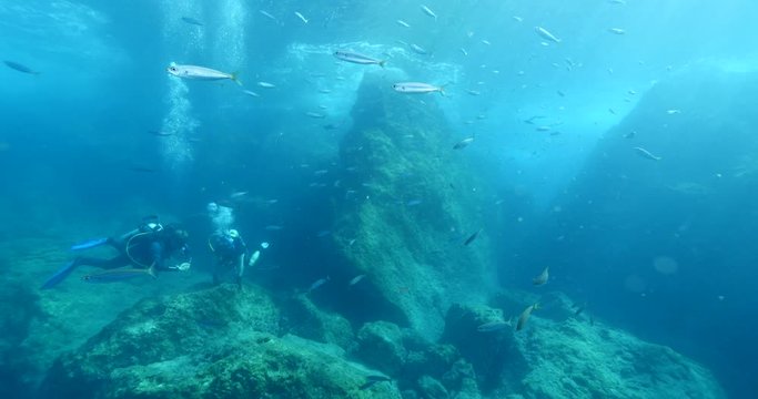 scuba divers picking old nets and fishing cages underwater ghost hunting dangerous ocean scenery