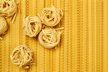 background of dried pasta, tagliatelle and mafaldini