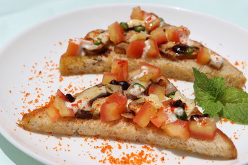 Brushetta or tapas with savory mushroom topping on white plate. Italian antipasti appetizer open toast sandwich