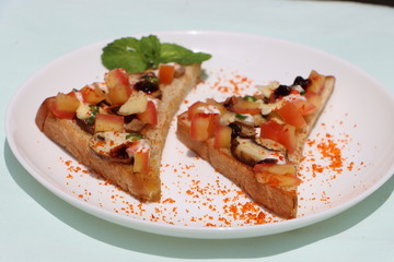 Brushetta or tapas with savory mushroom topping on white plate. Italian antipasti appetizer open toast sandwich