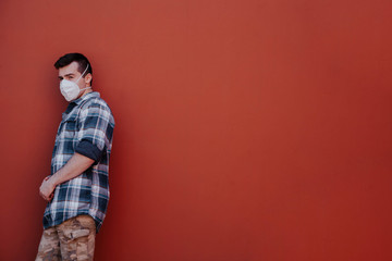 a masked man is leaning against a red wall