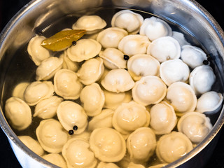 cooking Pelmeni (russian dumplings filled with minced meat) in steel stewpot