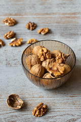 bowl with walnuts on wooden table vertical