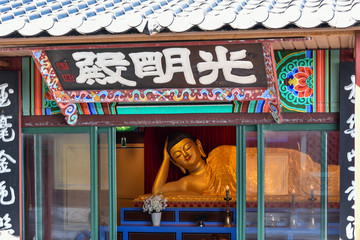Busan city, South Korea - NOV 01, 2019: Chinese culture golden Buddha sculpture that standing on the respective shrine near Haedong Yonggung Temple.
