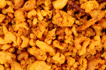 Batter scraps background texture, also known as batter bits or dubs, they are pieces of deep-fried batter left over in the fryer as a by-product of frying fish, and are served as an accompaniment to c