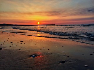 Colorful sunrise in Eraclea Mare. Sun going up in the morning with the shore of Adriatic sea on the beach in Italy.