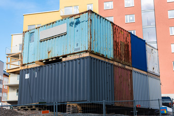 Stack of contaners by a newly built apartment complex.