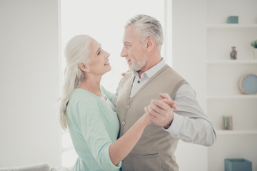 Obraz premium Profile side photo of charming spouses wear teal brown pullovers look in eyes move like in dance floor stand in their room apartment