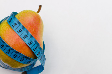 close-up pear in a centimeter tape, diet and fitness