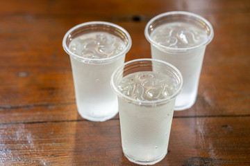 Plastic ice water on wooden table.