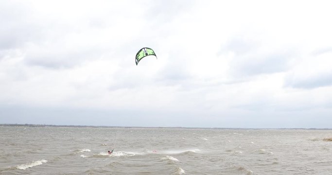 A man rides a kite on a lake