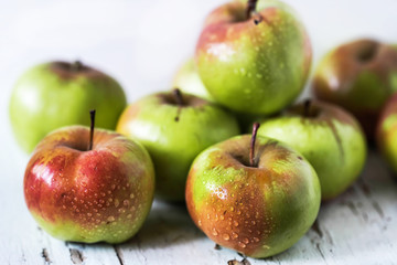 red and green apples on the table close up on a light background