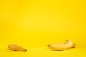 Banane isolate su sfondo giallo - obrazy, fototapety, plakaty