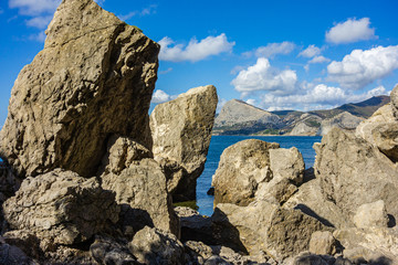 Rocky coast of Black Sea. Cape Alchak. Wildlife near ancient city built by Genoese. Velvet season in Sudak in Crimea. Huge stones and boulders in sea and on background of sea. Close-up.