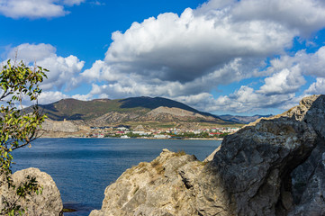 Fototapeta na wymiar View of fortress wall of Genoese fortress from Cape Alchak. Oldest tourist attractions of resort town is located on steep cliffs emerging from depths of sea. Sudak, Crimea, Russia - October 2, 2019.