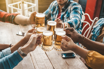 Groep mensen die genieten van en een biertje roosteren in brouwerijcafé - Vriendschapsconcept met jonge mensen die samen plezier hebben