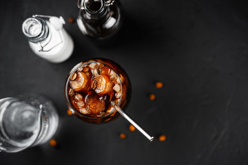 Cold brew coffee in a glass with metal straw on a dark background.Iced coffee	