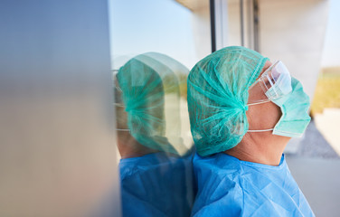 Arzt in Schutzkleidung macht Pause wegen Stress und Erschöpfung