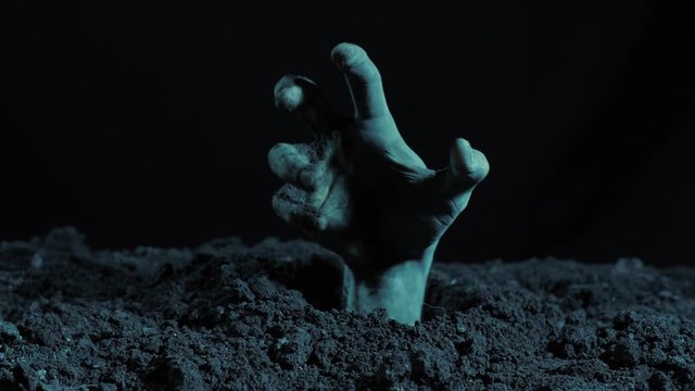 Zombie hand rising out from the grave