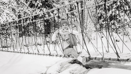 girl goes on a rope bridge in winter. Winter in Karelia. Suspension bridge