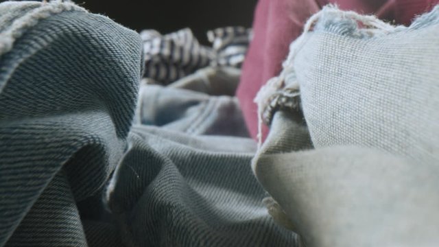 Close-up dollyshot of cloth textures with jeans and pullover