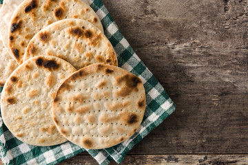 Handmade matzah for Jewish Passover on wooden table. Copy space