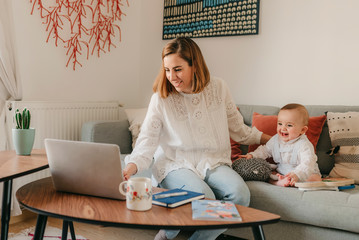 young business mother works from home with her cute baby