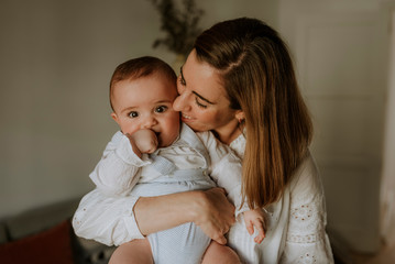 young smiling mother with baby in her arms