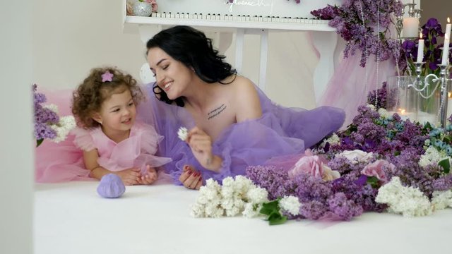 mother and daughter playing in the bedroom among flowers