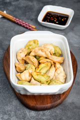 Fried dumplings in a white deep plate on a gray background
